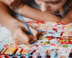 Young teen girl enjoying painting by numbers picture. Creative hobby. Leisure activity.
